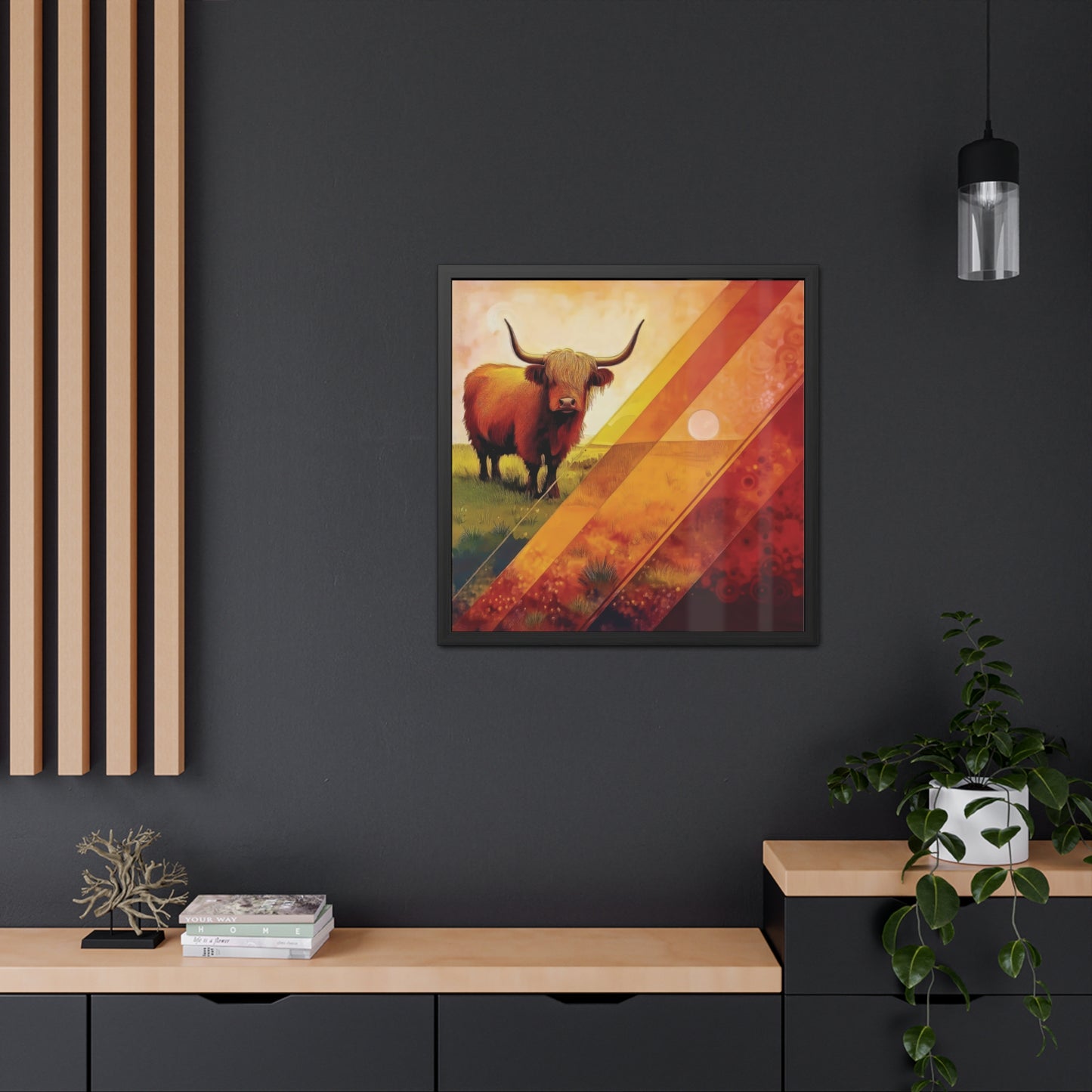 A Highland cow stands on grassy plains, framed by bold orange and yellow geometric patterns. Framed Poster on a dark wall.